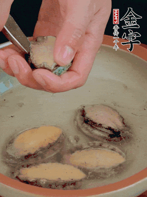 鮑魚加鹽、清水浸泡，用勺子挖出鮑魚肉。