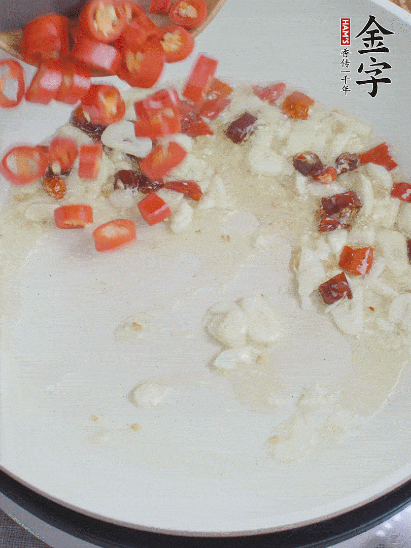 油6成熱，下蒜末、干紅辣椒煸炒，出香味后再放美人椒、香腸。