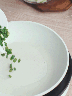 熱油下臘肉、蔥花煸炒，再下西葫蘆。